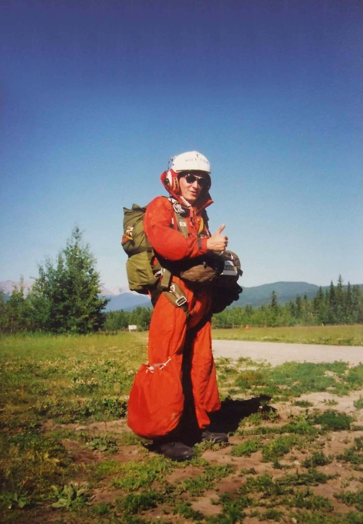 Prêt pour le dernier saut en juillet 1990 lors de son dernier examen d’entraînement de technicien en recherche et en sauvetage, le sergent André Hotton regarde sa combinaison à jambes bouffantes et fait une grimace : pendant son affectation à Edmonton, cette partie de la combinaison s’est prise dans une corde de parachute pendant son premier saut d’exercice, et il s’est cassé la jambe en plein vol. PHOTO : Fournie